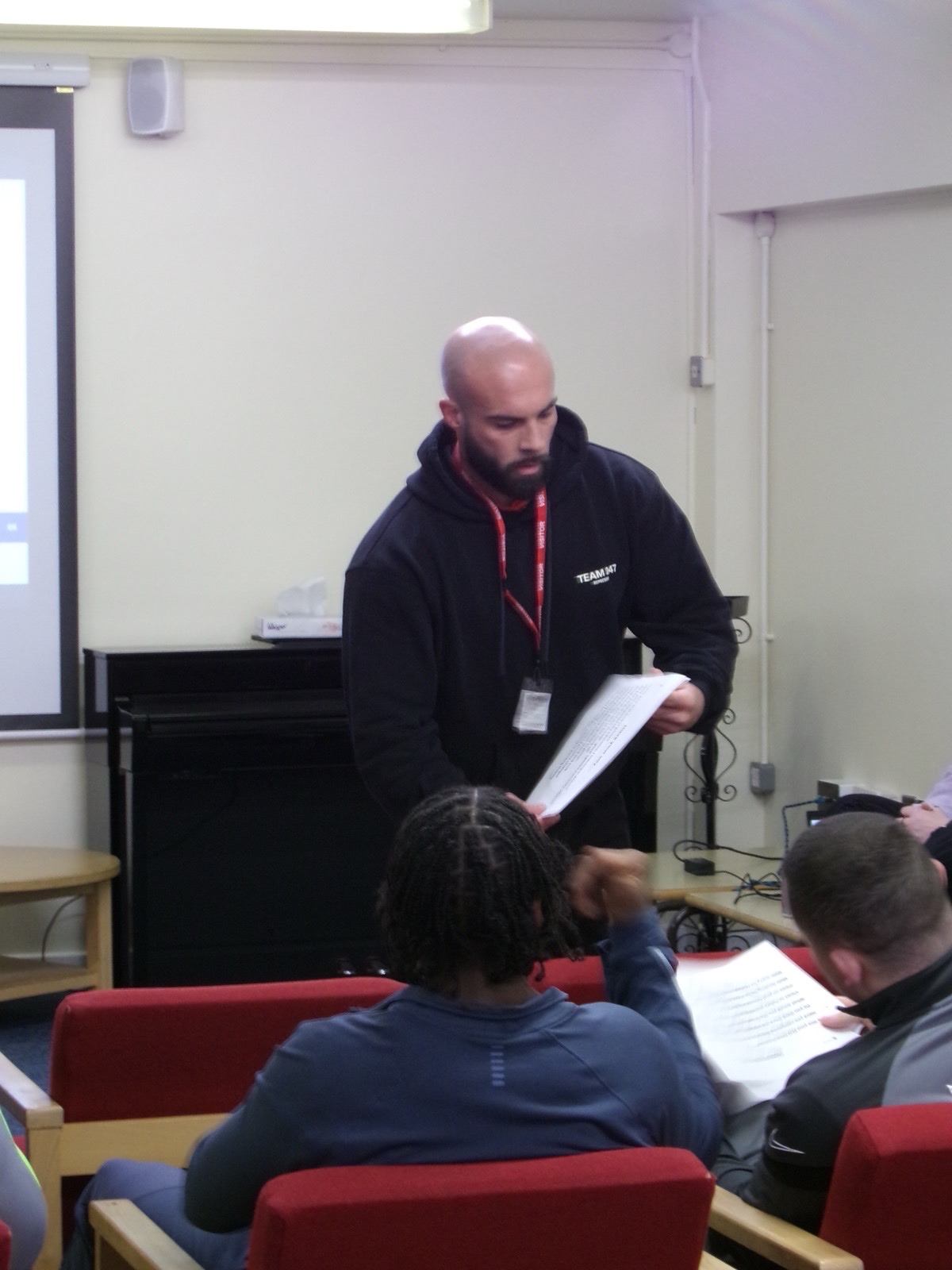 Stephen Bell handing out course materials to participants during a session in prison